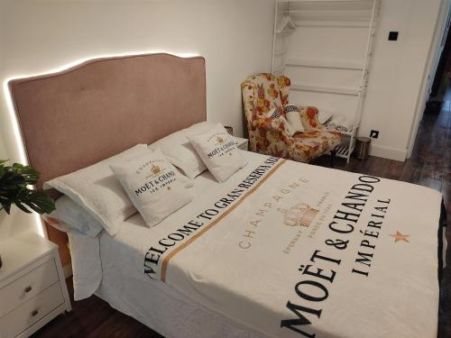 洛格罗尼奥Gran Reserva Suites centro alojamiento entero的一间卧室配有一张带被子和椅子的床