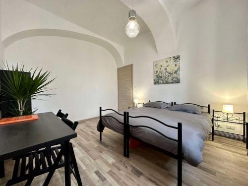 库尼奥Al Belvedere Affittacamere的一间卧室配有一张床、一张桌子和一张桌子。