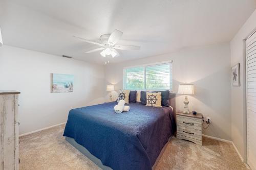 安娜玛丽亚South Bay Inn 4的一间卧室配有一张蓝色的床和吊扇