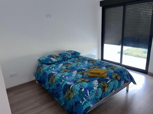 圣热讷维耶夫代布瓦VILLA LENA的卧室内的一张带蓝色棉被和枕头的床