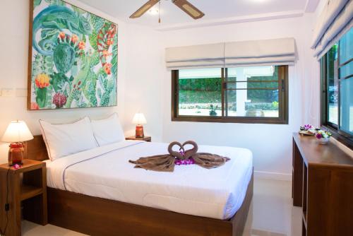 苏梅岛Villa Stella 16 Santi Thani Maenam的一间卧室,配有一张床,床上有一个弓