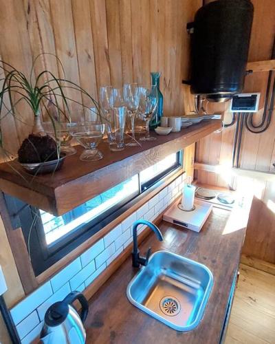 波萨达斯Aerohouse的厨房配有水槽和玻璃杯,位于柜台上