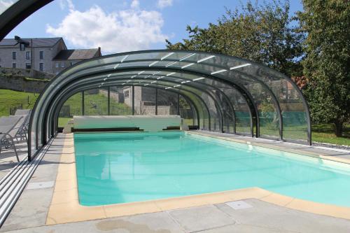 BiesmeréeLe grenier de la Floye的一座游泳池,上面有一座玻璃桥