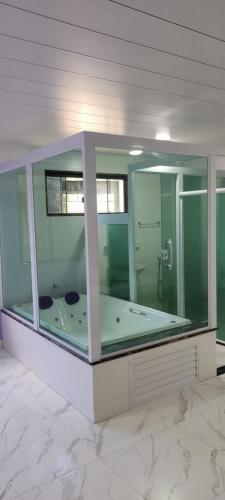 卢米亚Pousada Hotel Lumiar的一间玻璃外墙内大浴室,内配浴缸