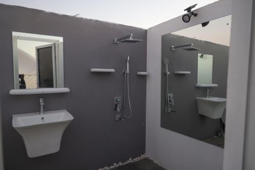 Shāhiq游猎沙漠营地度假酒店的浴室设有2个水槽和2面镜子