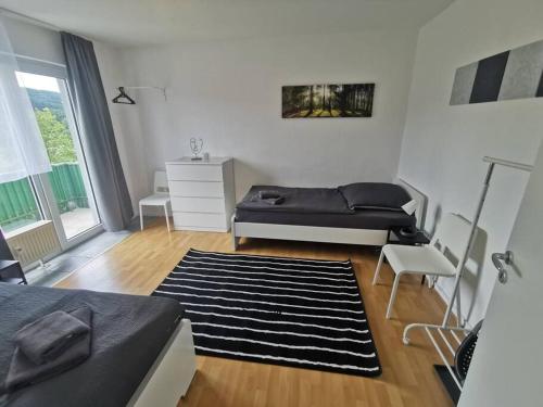 Herscheid1 room Apartment in Herscheid的一间卧室配有一张床、一张沙发和一张桌子