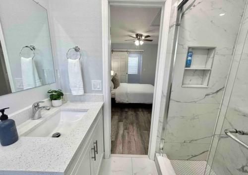 西棕榈滩Downtown West Palm Apartment Near Airport的带淋浴、盥洗盆和镜子的浴室