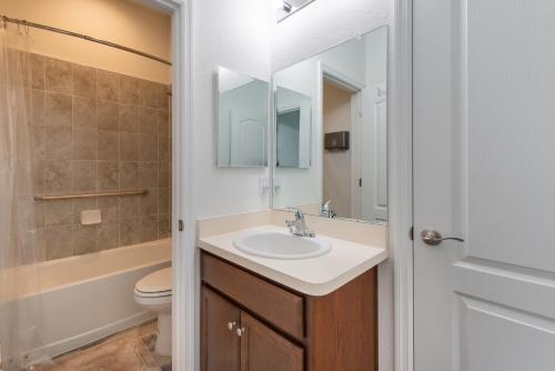 埃文帕克Avon Lakefront的一间带水槽、卫生间和镜子的浴室
