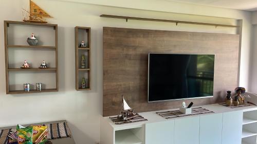 伊波茹卡Flat Confort Pé na Areia的客厅设有壁挂式平面电视。