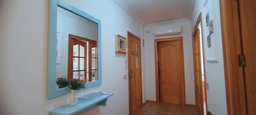 普里埃格·德·科尔多巴Apartamento Puerta Grana Priego.的走廊上设有蓝色长椅和镜子
