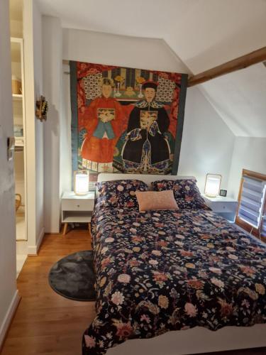 Thiers-sur-ThèveCountryhouse close to Senlis and Parc Asterix的卧室配有一张床,墙上挂有绘画作品