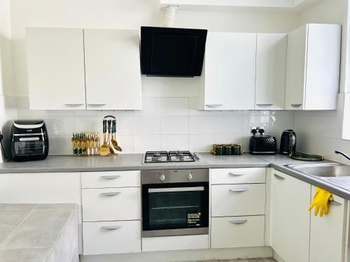 伦敦Luxury Morden 4 bedroom Flats which will make you unforgettable的厨房配有白色橱柜和炉灶烤箱。