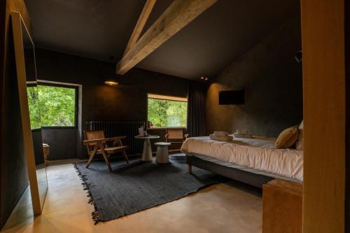 昂古莱姆La Maison des Sources的一间卧室配有一张床、一张桌子和两个窗户