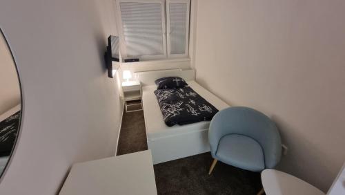 MošnovUbytování na letišti Ostrava Mošnov的小房间设有一张床和一张蓝色椅子