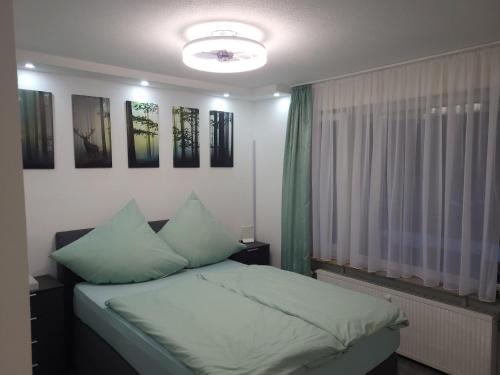 恩茨克勒斯特勒Schwarzwaldsuite mit Panorama Waldblick的一间卧室配有一张带绿色枕头的床和一扇窗户