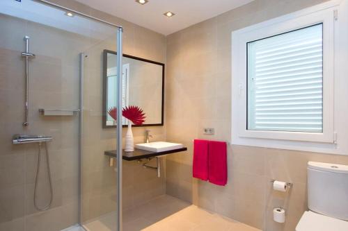 卡门港Villa Coral的一间带玻璃淋浴和水槽的浴室