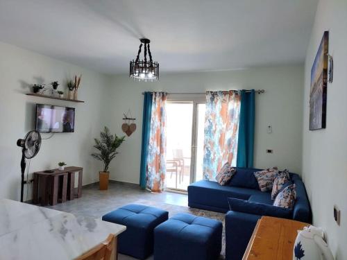 艾因苏赫纳The Groove Ain Sokhna的客厅设有蓝色的沙发和窗户。