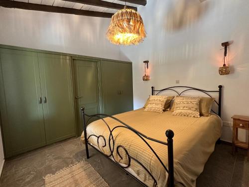 ArakapasJennas House的一间卧室配有一张带绿色橱柜和吊灯的床。