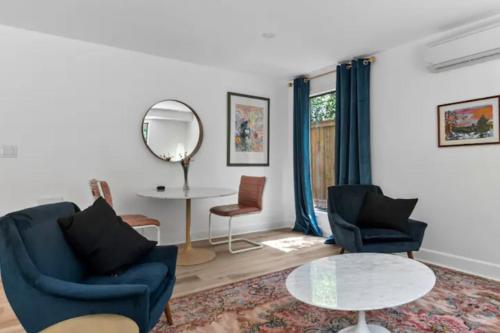西基隆拿Mid-Century Modern Dream Retreat的客厅配有两把椅子、一张桌子和镜子