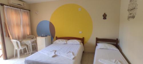 乌巴图巴Suítes Jardim dos Sonhos的一间卧室设有两张床和黄色的墙壁