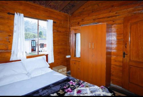 乌提Sandy Wood House Ooty - 2Bhk Villa的卧室配有白色的床和窗户。