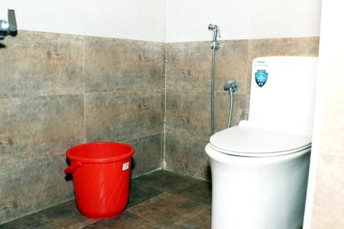 乌提Sandy Wood House Ooty - 2Bhk Villa的浴室里厕所旁的红色桶