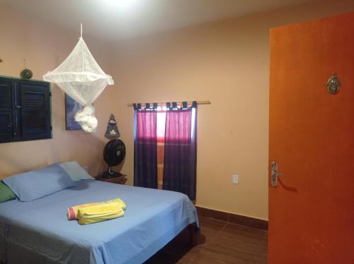 阿拉卡蒂MERMAID HOUSE, casa charmoso, wifi, parking, jardim, cozinha, central CANOA QUEBRADA的一间卧室配有一张带蓝色床单的床和一扇窗户。