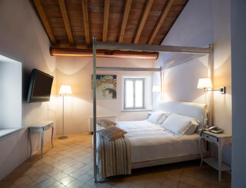 英杜诺欧罗纳Locanda Cà dei Santi的一间卧室配有一张床和一台电视