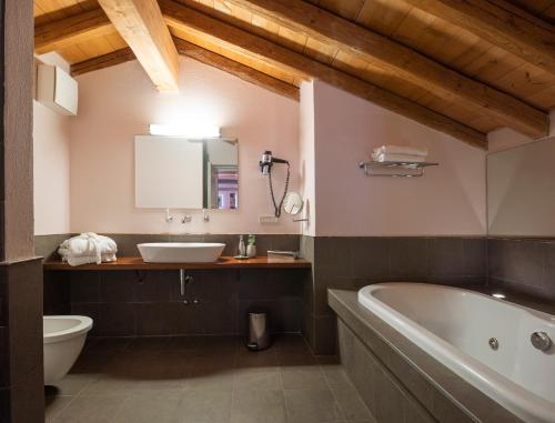 英杜诺欧罗纳Locanda Cà dei Santi的带浴缸、卫生间和盥洗盆的浴室