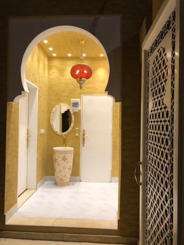 Al Khabrāʼشاليه غرناطة的走廊上设有门、镜子和花瓶