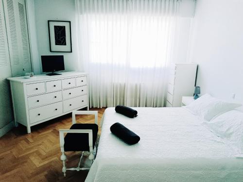 马德里Casa de Mirtha的卧室配有白色的床和白色梳妆台