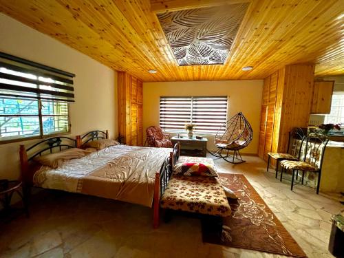 阿杰隆Oak Farm مزرعة الملّول的一间卧室设有一张带木制天花板的大床