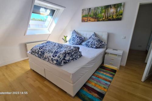 卡尔斯鲁厄Modernes Apartment mit 3 Zimmern的一间卧室配有一张带蓝色和白色枕头的床