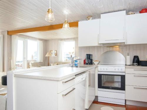 森讷比6 person holiday home in Juelsminde的厨房配有白色橱柜和炉灶烤箱。