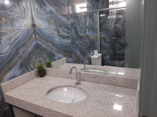戈亚尼亚Luxo e conforto的一间带水槽和花岗岩墙的浴室