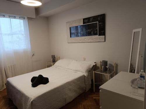 马德里Casa de Mirtha的一间卧室,配有一张带黑色帽子的床
