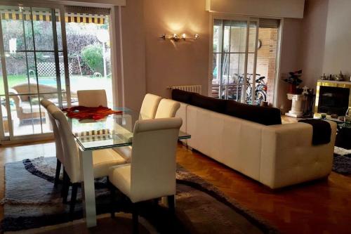 马德里Casa de Mirtha的客厅配有白色沙发和玻璃桌