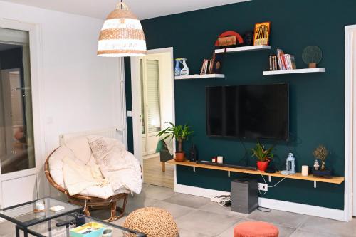 马恩河畔维列Cosy Colour Place的客厅配有电视和椅子
