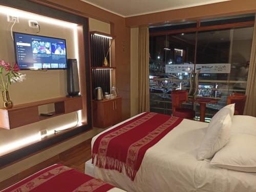 马丘比丘Hs Tierra In的酒店客房设有一张床和带电视的窗户。