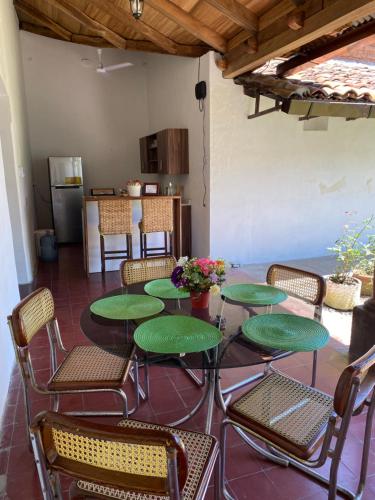 SuchitotoCasa Colonial的一个带绿色桌椅的庭院和一间厨房