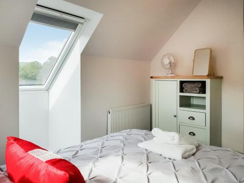 福克兰Palace View - Uk40569的一间卧室配有一张带红色枕头的床和窗户