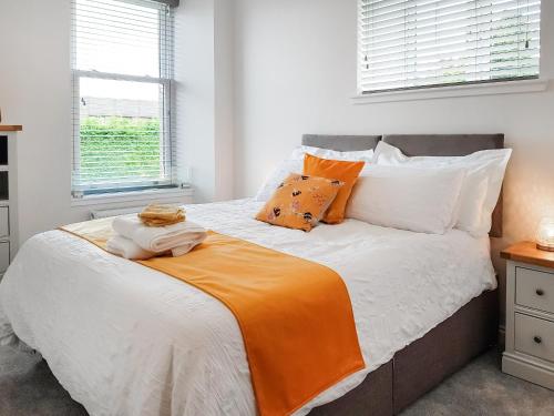 福克兰Invergyle - Uk40566的一间卧室配有一张带橙色毯子的床