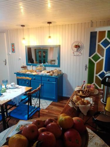 邦雅尔丁-达塞拉Pousada Vivenda das Flores Ltda的厨房配有蓝色橱柜和水果桌