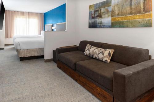 巴吞鲁日巴吞鲁日南万豪春季山丘套房酒店的客厅配有沙发和1张床