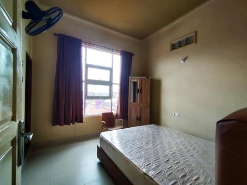 巨港Rian Kost - Hotel Penginapan Murah Pusat Kota Palembang的一间卧室设有一张床和一个窗口