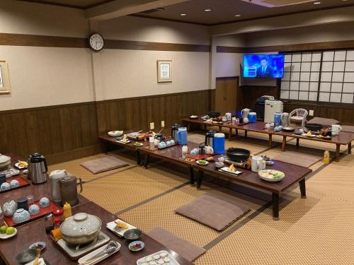 京都旅荘茶谷日式旅馆的一间设有餐桌和电视的房间