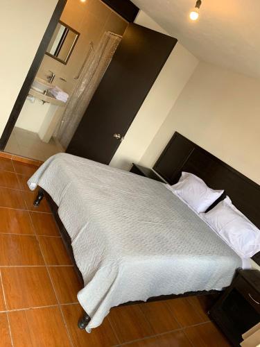 GuadalupeFinca del Rincón的卧室配有一张带白色床单和枕头的大床。