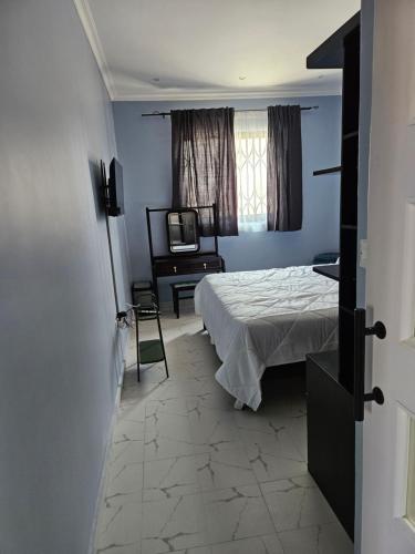 卢萨卡Villa Serene的一间卧室配有一张床和一台电视