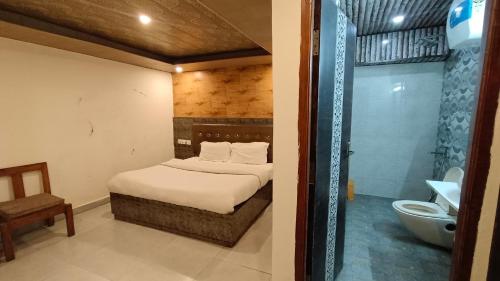 西姆拉Shimla Royale - Near Mall Road Free Pickup From Railway Station Shimla的一间卧室配有一张床,浴室设有淋浴。