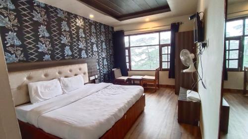 西姆拉Shimla Royale - Near Mall Road Free Pickup From Railway Station Shimla的一间卧室,卧室内配有一张大床